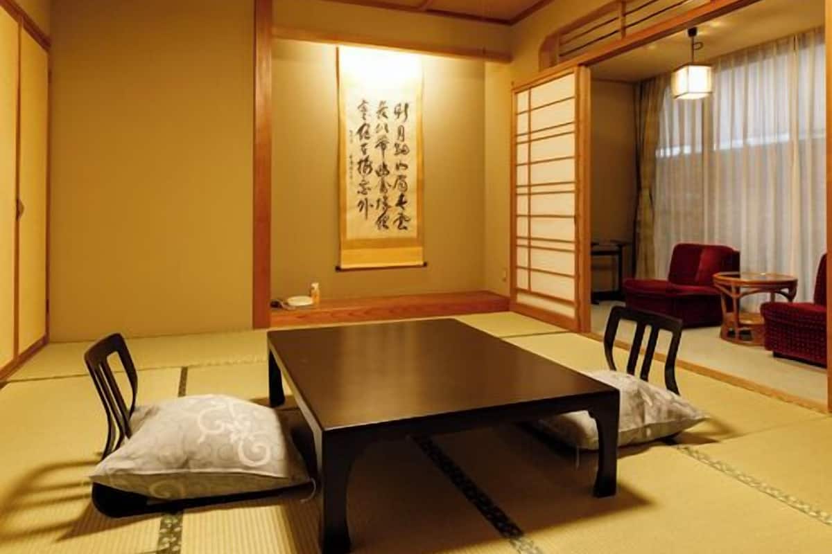 Une pièce de style japonais traditionnel, avec un sol recouvert de tatamis, une table basse et une porte coulissante.