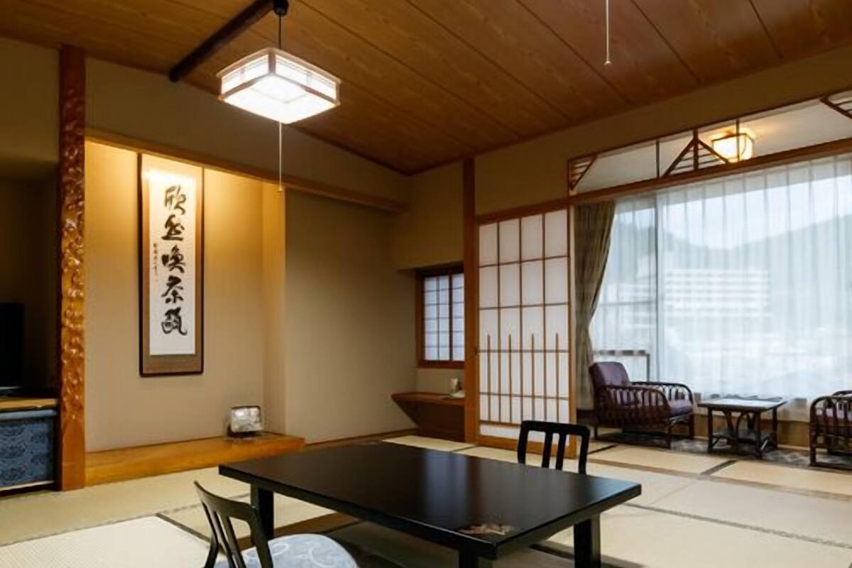 A traditional Japanese room with tatami flooring, a low table, and sliding doors.