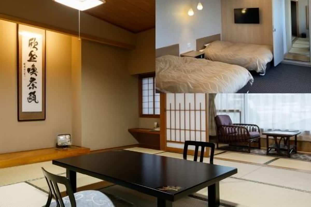 Une pièce de style japonais traditionnel, avec un sol recouvert de tatamis, une table basse entourée de chaises, un lit et un téléviseur.