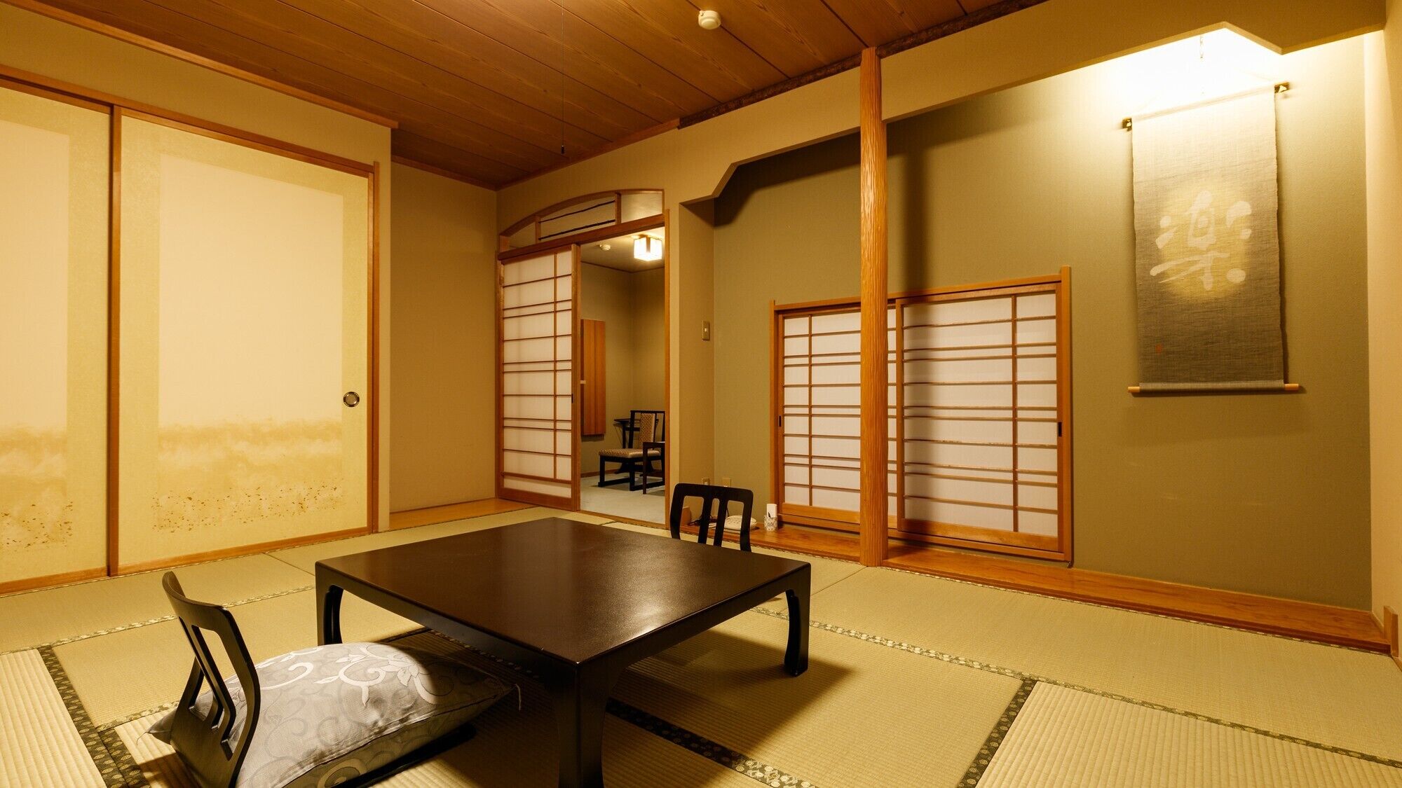 A traditional Japanese room with tatami flooring, a low table, and sliding doors.
