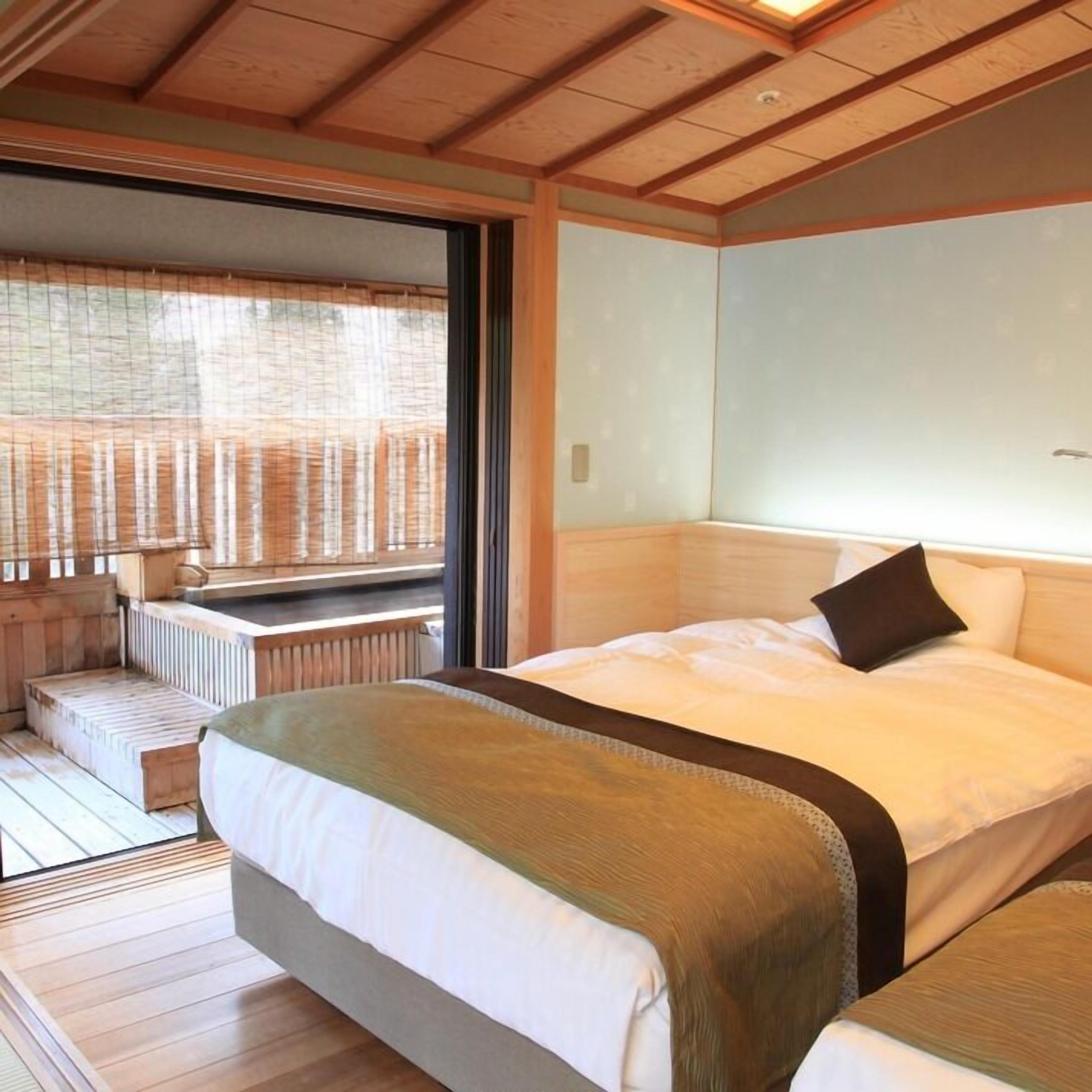 Ein Zimmer mit einem großen Bett, einer Bank und Blick durch ein Fenster.