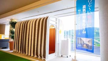 A modern hotel interior with a unique, curved wall structure, a large window offering a view, and a blue banner with text.