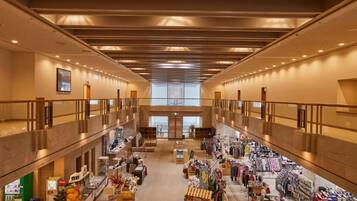 A spacious indoor shopping area with multiple levels, retail stores, and a central staircase.