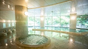 A spa area with a hot tub, large windows, and a view of greenery. - KAMOGAWA COUNTRY HOTEL (Kamogawa)