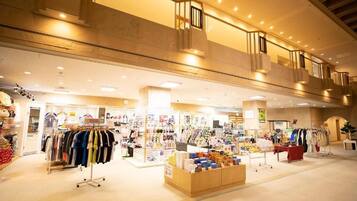 A multi-level shopping mall with various retail stores and a central display area.