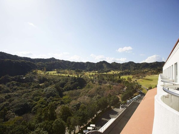 A balcony with a view of a green landscape and a parking area. - KAMOGAWA COUNTRY HOTEL (Kamogawa)