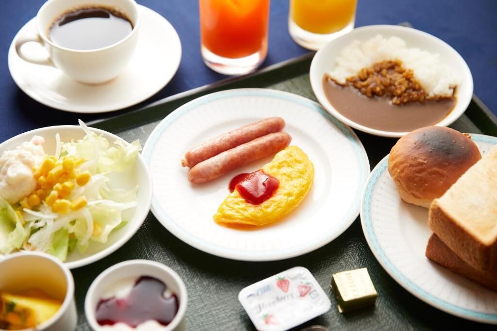 A breakfast tray with various food items including eggs, sausages, toast, and a salad.
