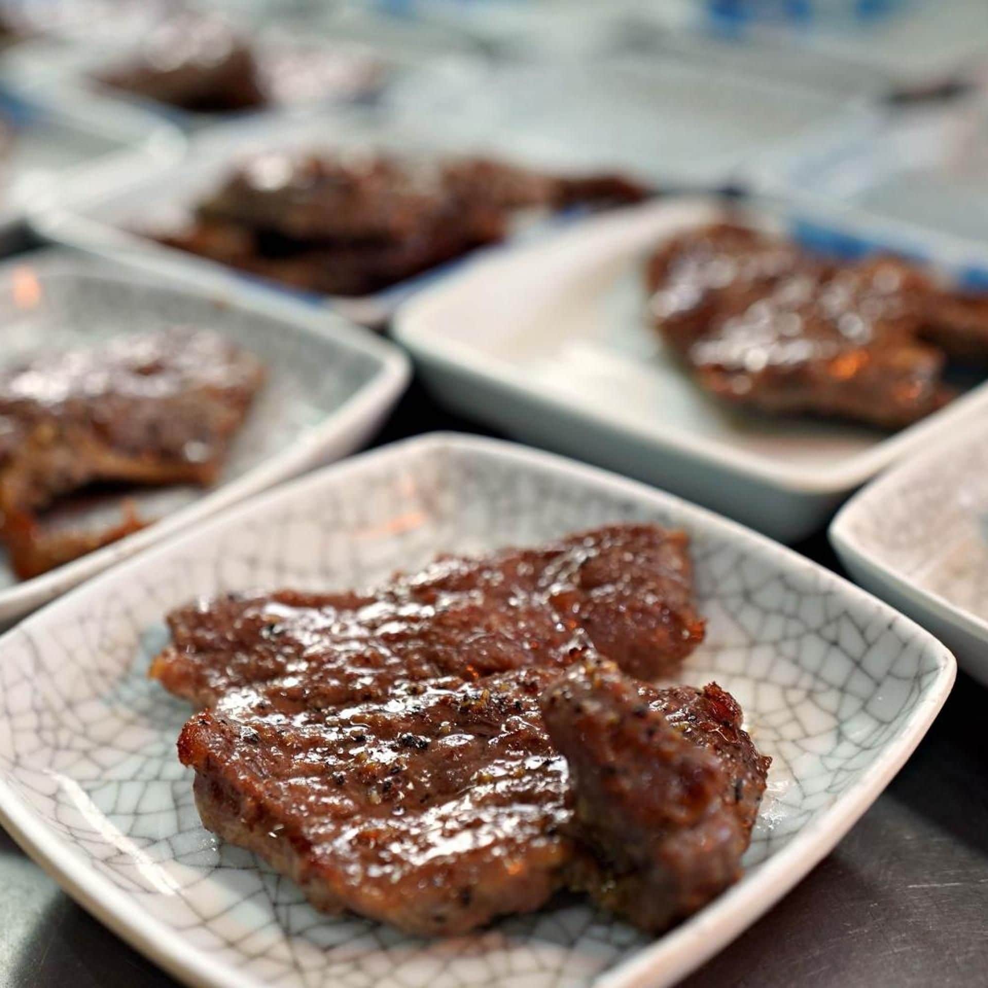 A selection of grilled meat dishes on ceramic plates.