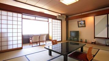 A traditional Japanese room with tatami flooring, a low table, and sliding doors.