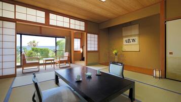 A traditional Japanese room with tatami flooring, a low table, and a view of the outdoors.