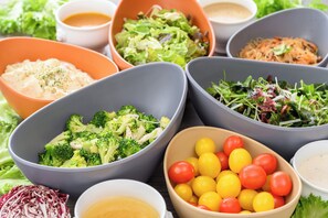 A variety of food bowls with different dishes, including salads and vegetables.