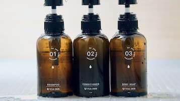Three bottles of VIA INN products on a tiled surface.