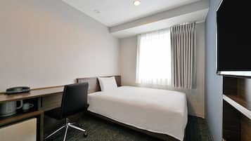 Habitación de hotel con cama, escritorio, silla, televisión y ventana con cortinas.