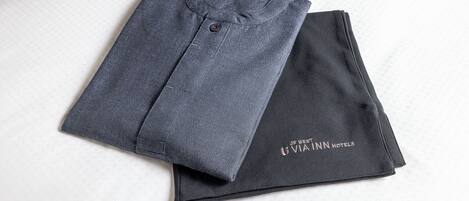 A folded garment with a visible button and a logo on the sleeve.