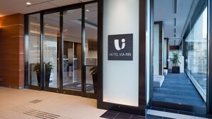 A modern hotel lobby with glass doors, a reception desk, and a staircase leading to upper floors. - JR WEST GROUP VIA INN OKAYAMA (Okayama)