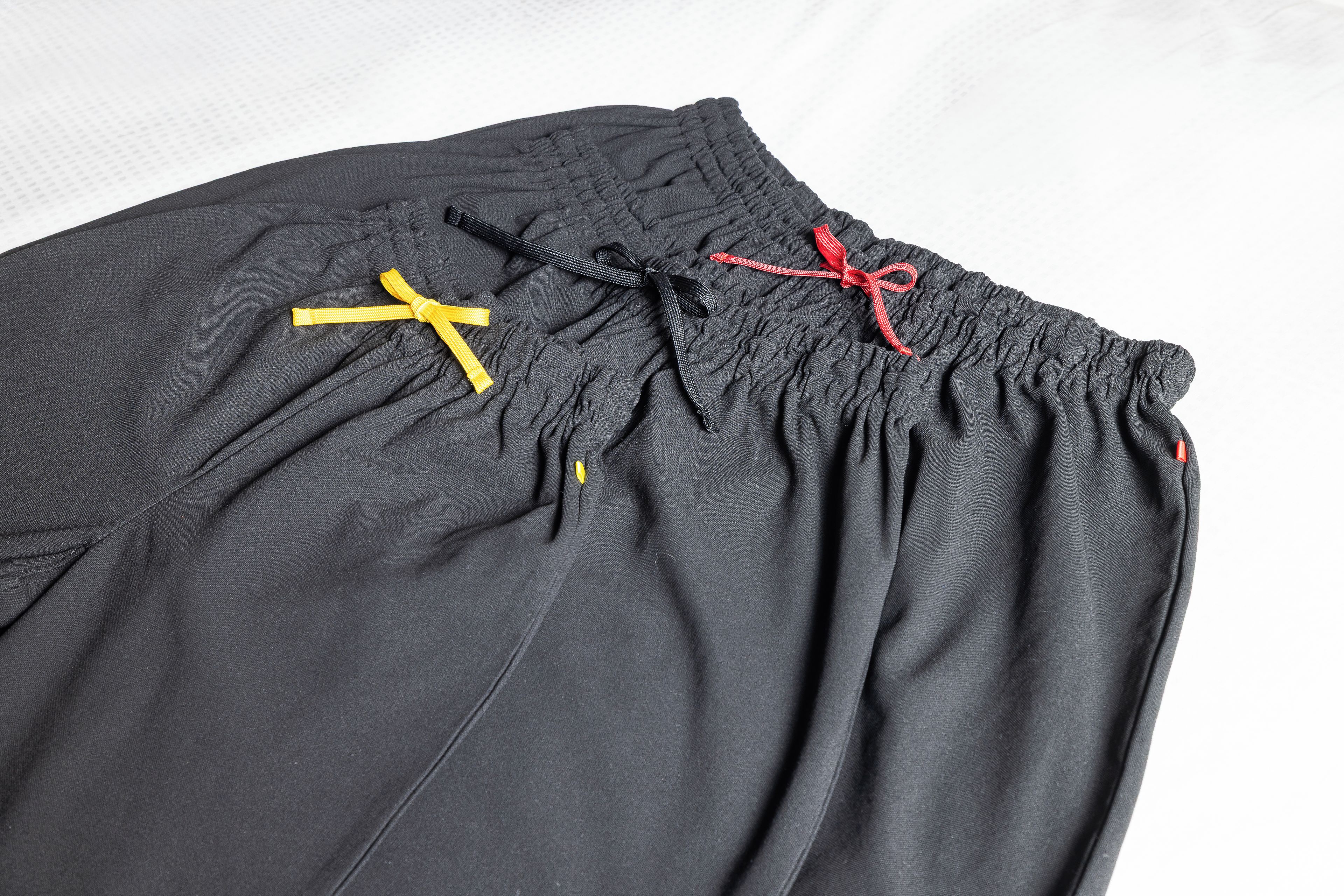 A piece of clothing with a drawstring and two ribbons tied in bows.