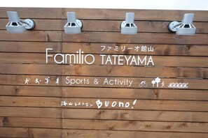 A wooden sign with the name "Familio TATEYAMA" and symbols for sports and activities.