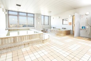 Et spa-område med stort vindue, jacuzzi og sauna.