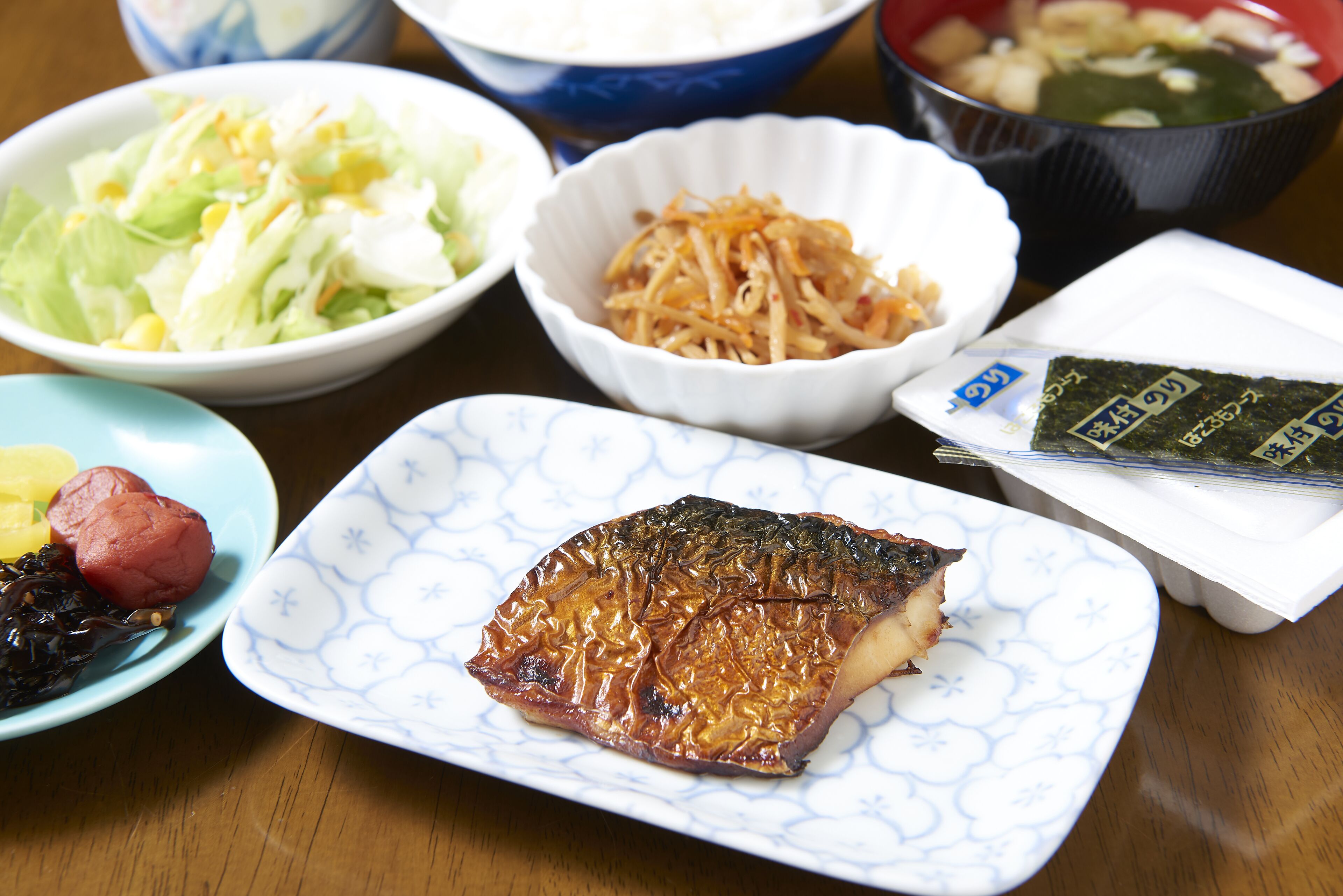 Ein Tisch mit verschiedenen Speisen, darunter Fisch, Salat und andere Gerichte.