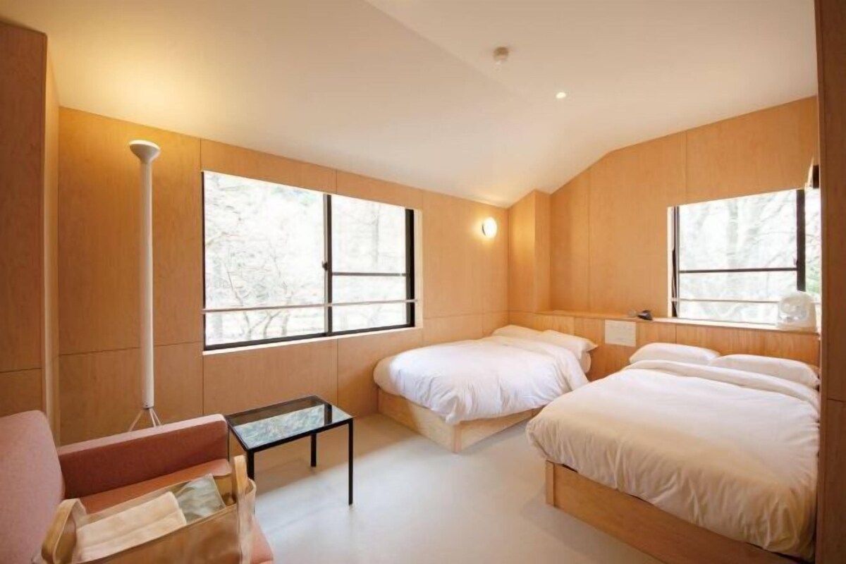 Une chambre moderne avec deux lits, une petite table et une chaise.