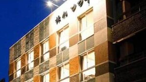 Een meerlaags gebouw met een geruit gevel, grote ramen en een bord met Japanse tekens.