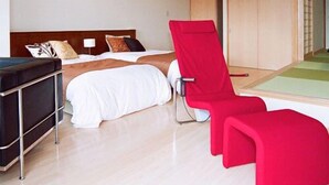 Een moderne hotelkamer met een bed, een rode stoel en een grote spiegel.