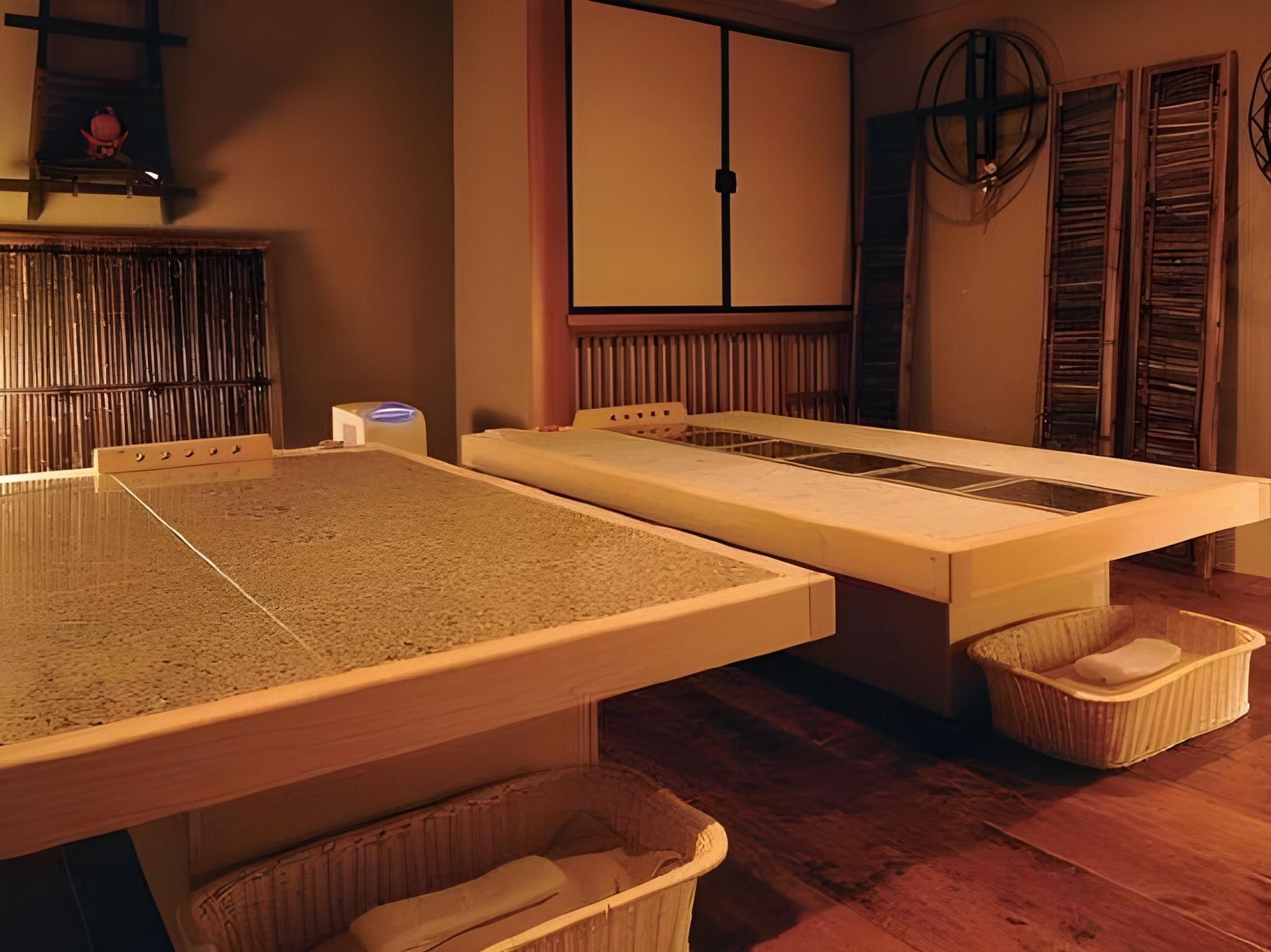 A traditional Japanese tatami mat room with a low table, a futon bed, and a wooden floor.