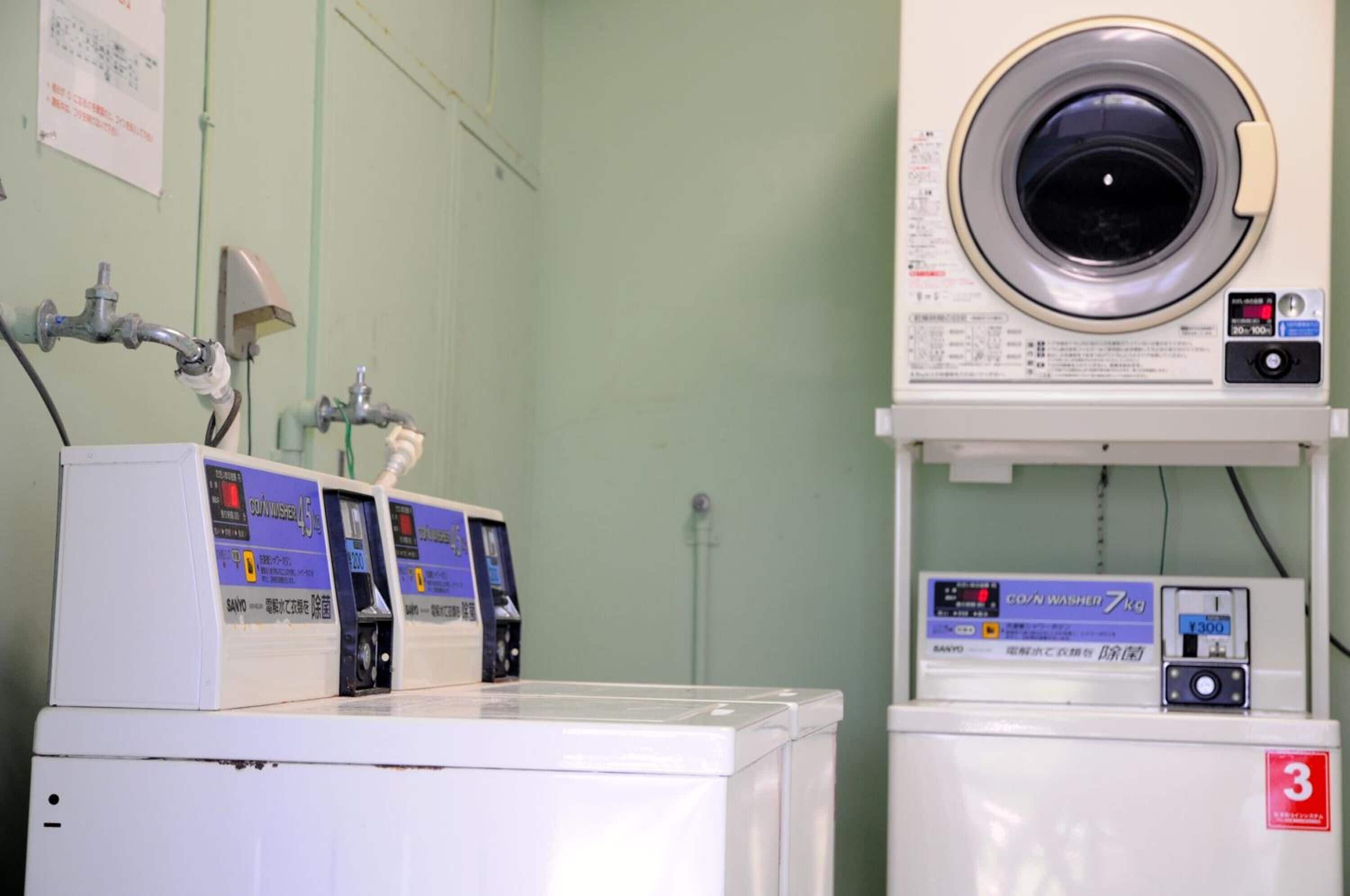 A laundry room with multiple washing machines and a large industrial washer.