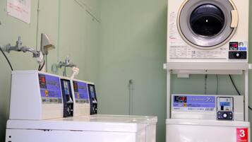 A laundry room with multiple washing machines and a large industrial washer.