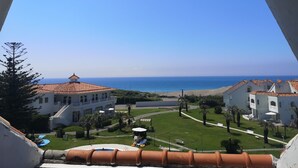 A view of a coastal area with a swimming pool, lounge chairs, and a beach. - Tateyama Resort Hotel (Tateyama)