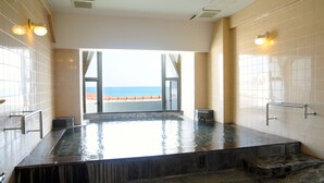 A spa area with a large hot tub, a view of the sea, and a tiled wall. - Tateyama Resort Hotel (Tateyama)