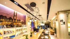 Uma biblioteca moderna com estantes de livros, computadores e áreas de estar.