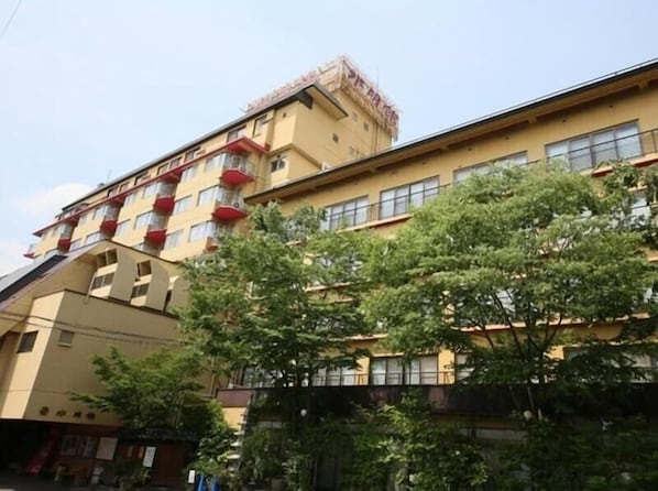 A multi-story building with balconies and a flat roof.