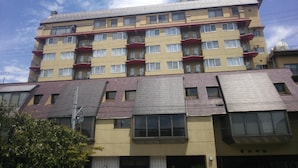 Um edifício de vários andares com varandas e uma placa em língua estrangeira.