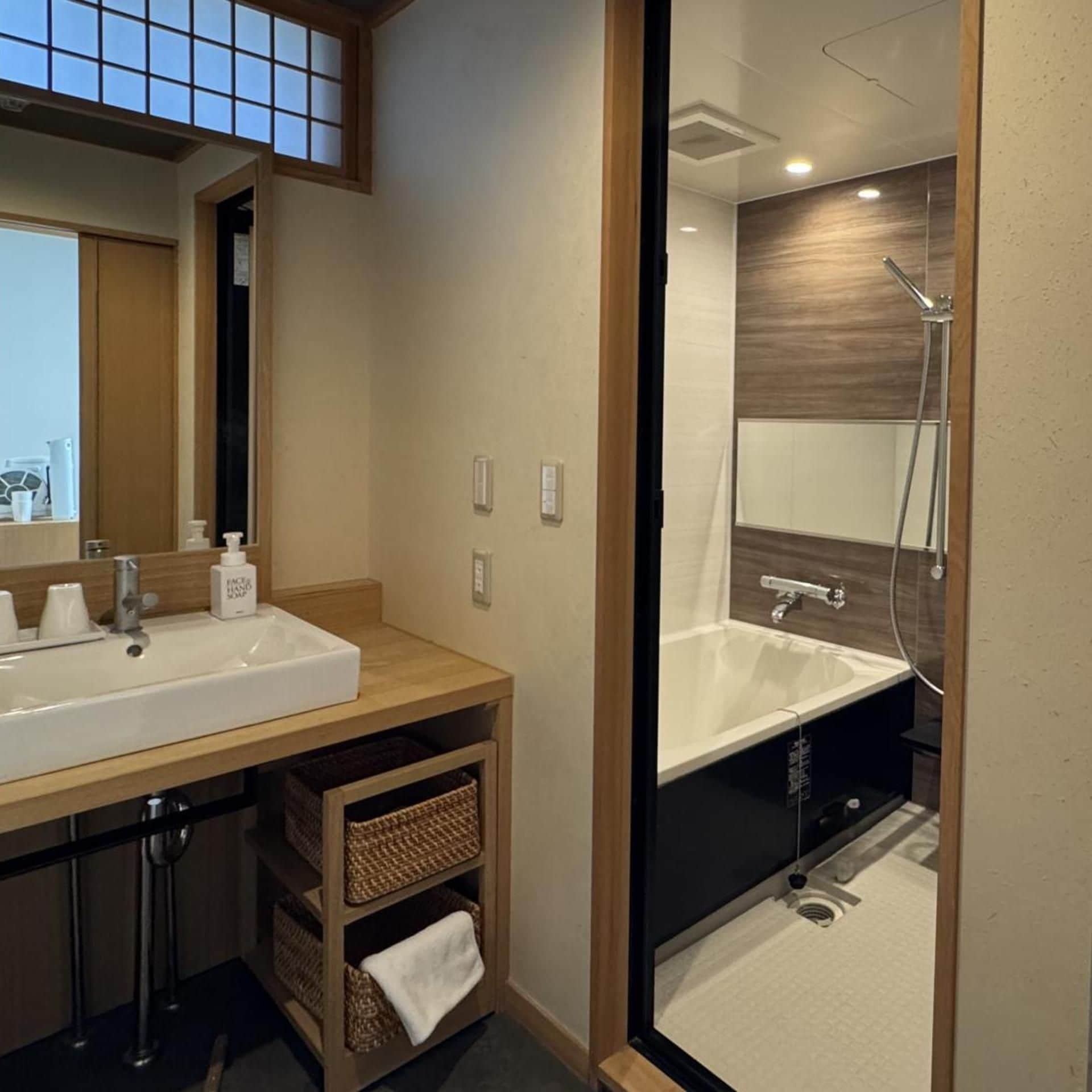 A modern bathroom with a large sink, mirror, and a separate shower area.