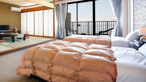 A hotel room with tatami flooring, a balcony with a view, a television, and a desk with a chair. - Washu Onsen Bizenya Koushi (Kurashiki)