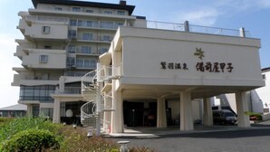 A multi-story building with a white facade, a covered entrance, and a spiral staircase. - Washu Onsen Bizenya Koushi (Kurashiki)