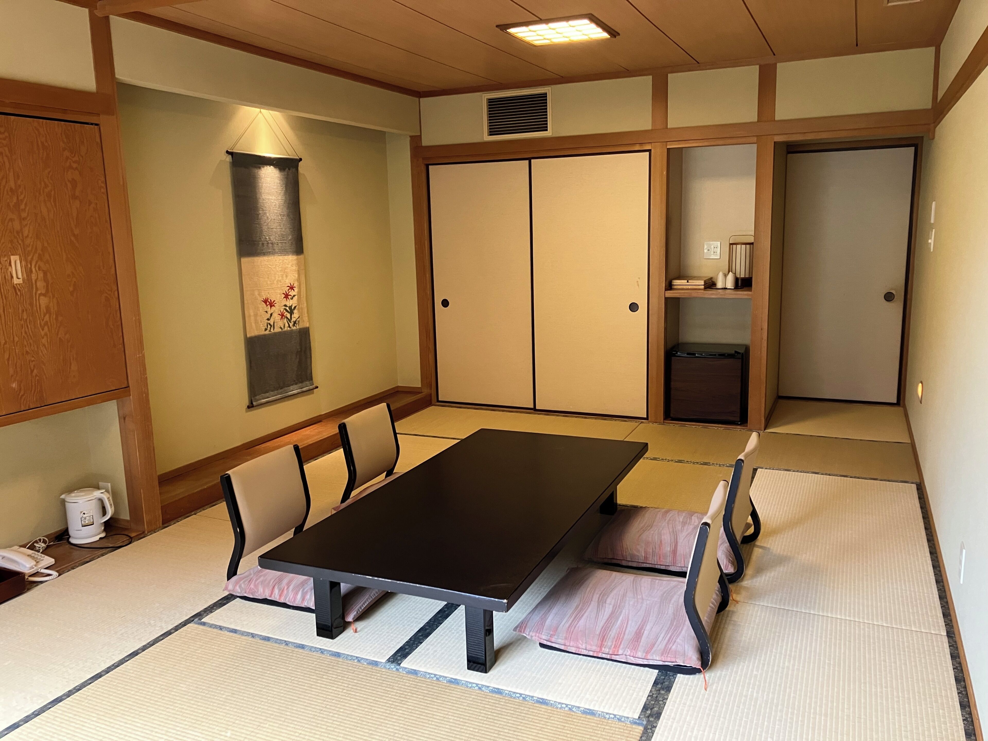 A traditional Japanese-style room with tatami flooring, a low table, and sliding doors.