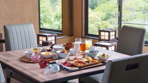 A dining table set with various dishes, glasses, and a teapot, surrounded by chairs and windows with a view of greenery. - Yukyo No Hibiki Yusai (Minamioguni)