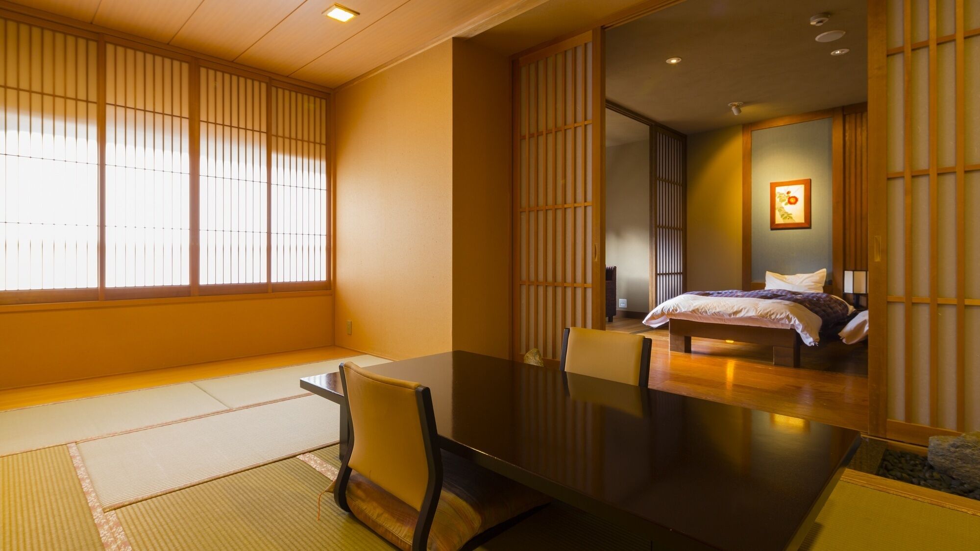 Een traditionele Japanse kamer met tatami vloerbedekking, een lage tafel en een bed met een futon.