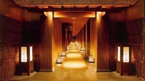 A hallway with a warm, illuminated path, wooden pillars, and traditional signage. - Yukyo No Hibiki Yusai (Minamioguni)