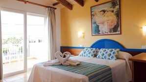A hotel room with a bed, a painting, and a view of the outside. - Sagitario Villas (Ciutadella de Menorca)