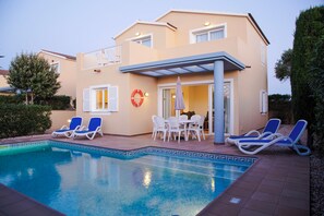 A two-story building with a swimming pool, outdoor seating, and a lifebuoy on the wall. - Sagitario Villas (Ciutadella de Menorca)