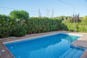 A rectangular swimming pool with clear blue water, surrounded by a low hedge and a tiled deck. - Sagitario Villas (Ciutadella de Menorca)