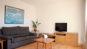 A living room with a sofa, a coffee table, a TV, and a cabinet.