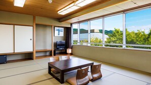 Een traditionele Japanse kamer met tatami vloerbedekking, een lage tafel en een televisie.