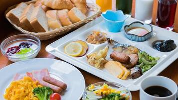 A breakfast buffet with various dishes, including eggs, bacon, sausages, and vegetables.