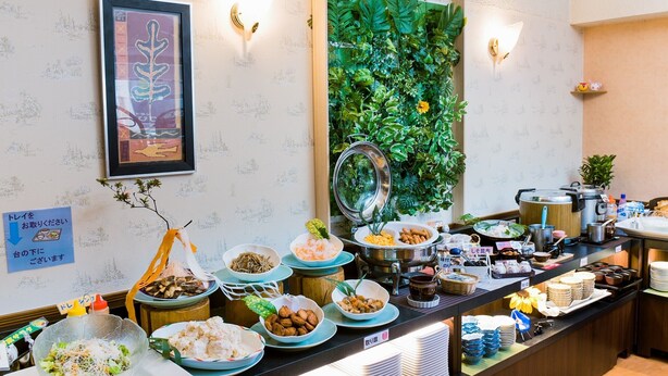 A buffet with various dishes, a wall-mounted plant, and a framed picture. - Hotel Taisei (Kagoshima)