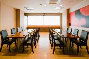 A conference room with a long table and chairs, a large window, and a modern abstract painting on the wall. - Hotel Taisei (Kagoshima)