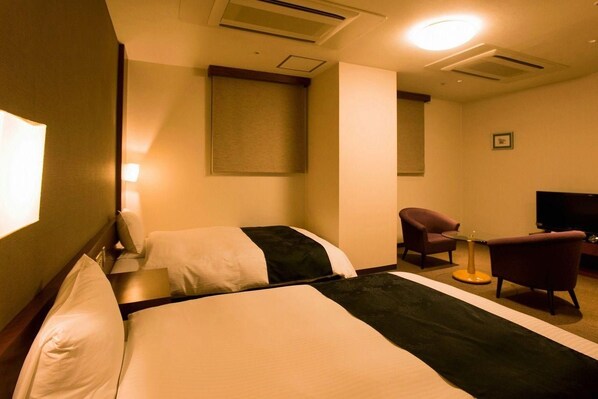 A hotel room with two beds, a desk, a chair, a television, and a window. - Hotel Taisei (Kagoshima)